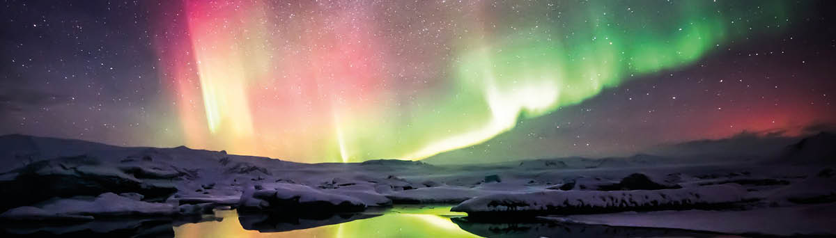 A beautiful green and red aurora dancing over the Jokulsarlon lagoon, Iceland
