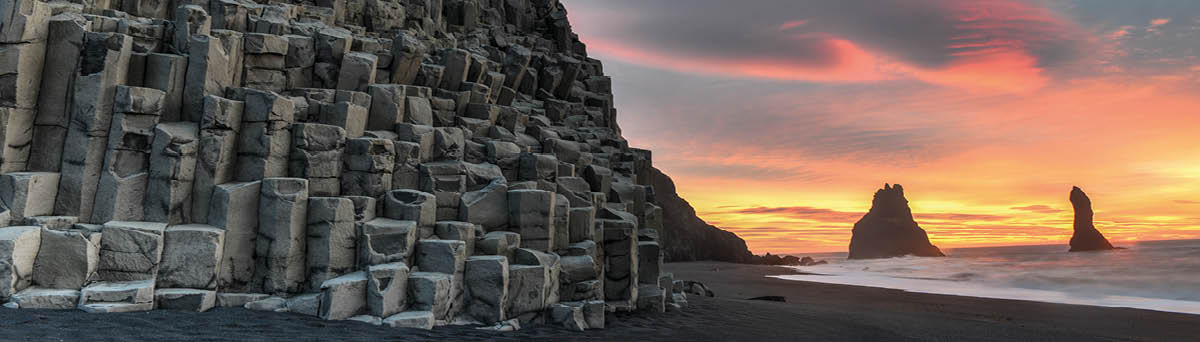 Wide view of Reynisdrangar rock formations on Reynisfjara Beach at sunrise, Halsanefhellir, Iceland 