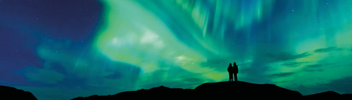 Aurora borealis with silhouette love romantic couple on the mountain Honeymoon travel concept