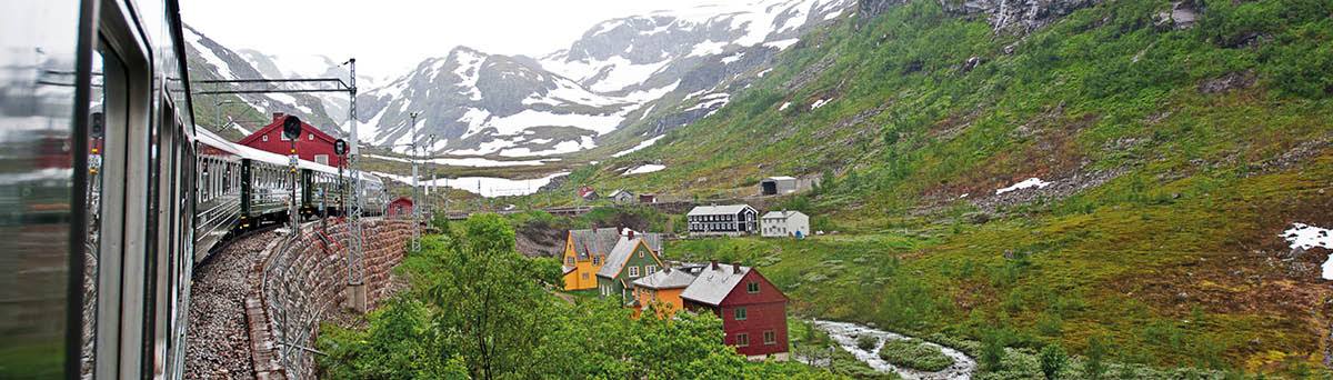 Passenger train of the Flåm Railway Line passes over the snow clad fields of the mountains and fjords  The line runs between Myrdal and Flåm in Aurland, Norway is a branch line of the Bergen Line, running through the valley of Flåmsdalen and connecting  with the mainline with Sognefjord