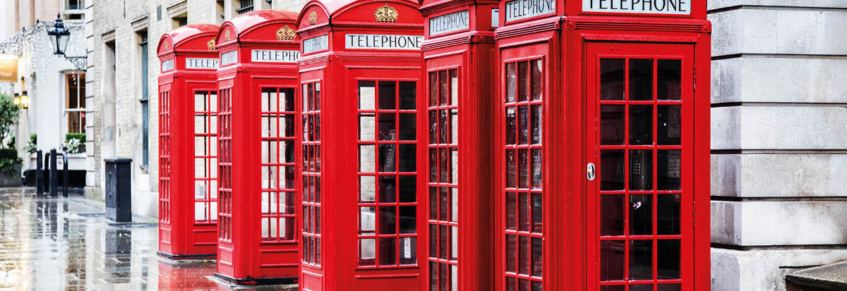 Five British red phone boxes in a row  A line of phone booths in Covent garden after the rain 