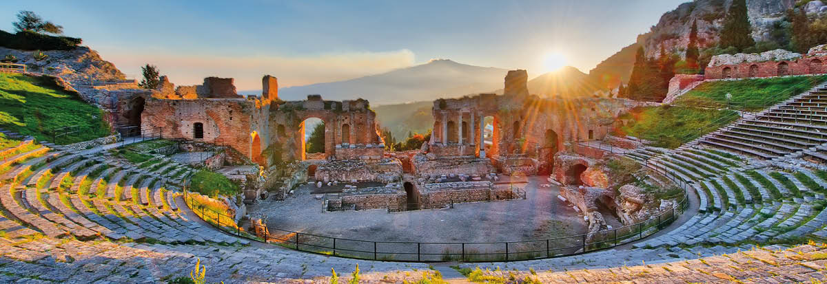 Ancient theatre of Taormina Siciliy Italy  with Etna erupting volcano at sunset
