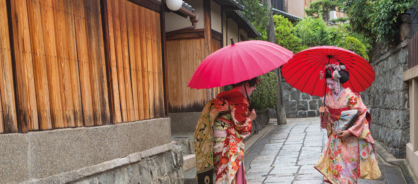 traditional geisha maiko girls salute eachother at street of kyoto japan