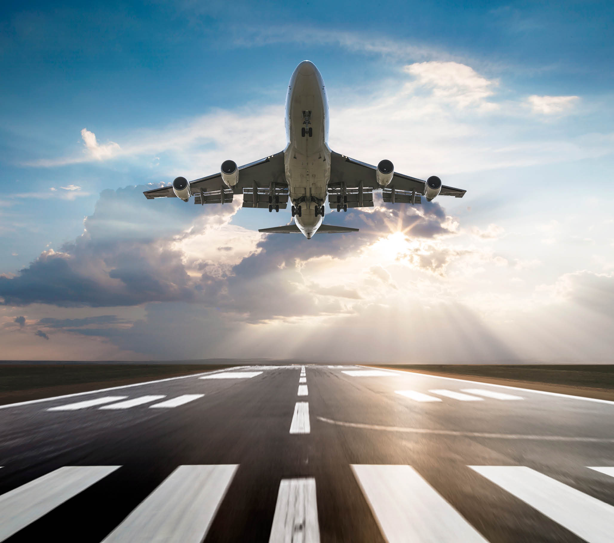 Passenger airplane taking off at sunset