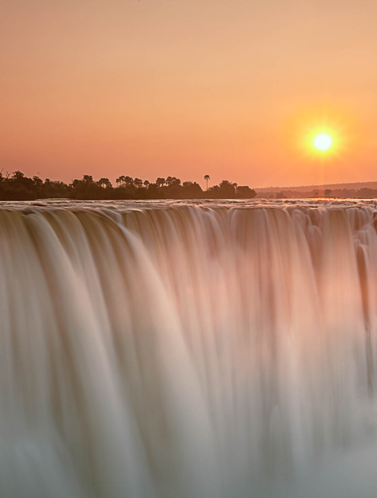 Sunrise breaks above Victoria Falls, Zimbabwe
