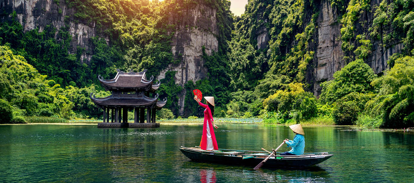 Asian woman wearing Vietnam culture traditional at Trang An, Vietnam.