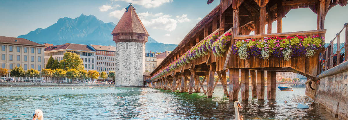 Historic city center of Lucerne with famous Chapel Bridge, the city's symbol and one of the Switzerland's main tourist attractions, and Mount Pilatus peak in the background, Switzerland