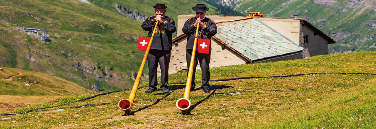 ZERMATT, SWITZERLAND - JULY 16, 2019: Swiss alphorn blowers are playing music near the Matterhorn mountain in the Alps, located between Switzerland and Italy