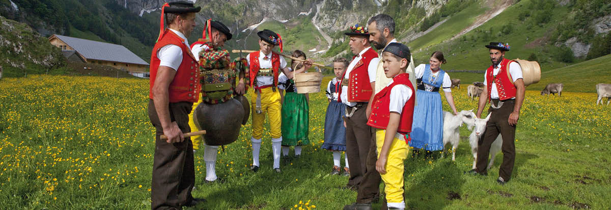 APPENZELL - Trachtenkinder und Sennen bei Jodelgesang ('Rugguusseli') nach der Alpauffahrt auf Seealp im Alpstein mit dem Saentis im Hintergrund   Children and Alpine herdsmen wearing traditional costume and yodelling ('Rugguusseli') after the traditional cattle procession to summer pastures to Seealp in Alpstein with the Saentis mountain in the background   Enfants en costume regional et bouviers jodlant ('Rugguusseli') apres la montee a l'alpage sur le Seealp dans l'Alpstein avec le Saentis a l'arriere-plan   Copyright by: Appenzellerland Tourismus AI By-Line: swiss-image ch Christof Sonderegger