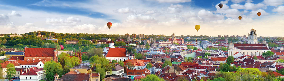 Beautiful summer panorama of Vilnius old town with colorful hot air balloons in the sky, taken from the Gediminas hill