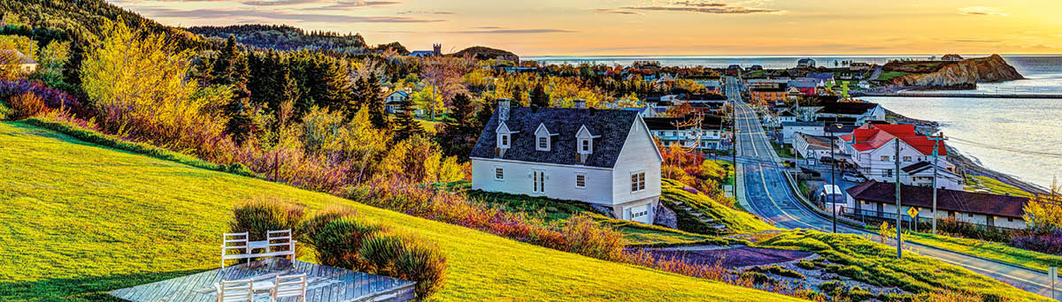 Hotel chairs on hill during sunrise in Perce, Gaspe Peninsula, Quebec, Canada, Gaspesie region with cityscape