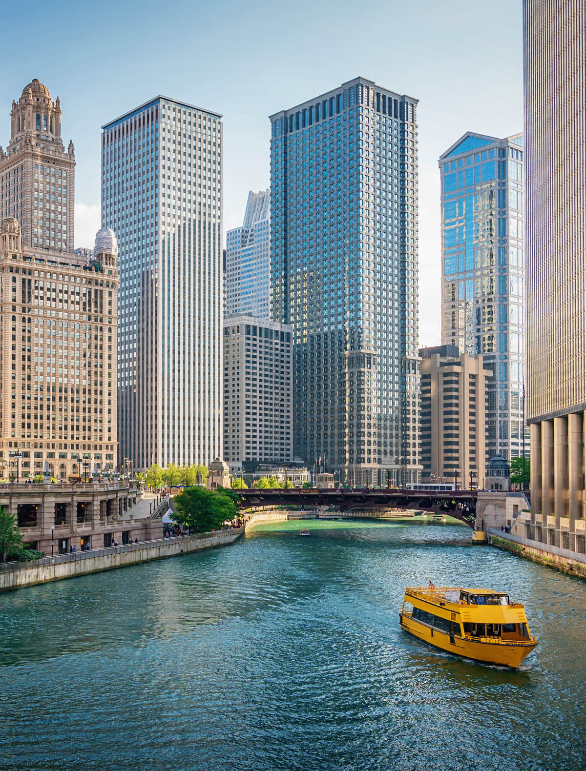 Downtown Chicago Skyscraper Cityscape along the Chicago River. Typical yellow Tourboat cruising on the Chicago River towards the Michigan Lake. Chicago, Illinois, USA.