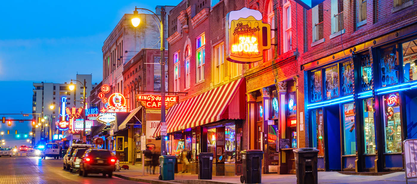 Photo of colorful cafe bars at the iconic Beale Street music and entertainment district of downtown Memphis, Tennessee, USA, illuminated at night.