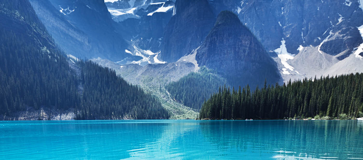 Lake Moraine in the Banff National Park, Alberta, Canada, features clear emerald water and snow-capped peaks of the Canadian Rockies mountain range. The scenic landscape is a famous place and a favorite tourist travel destination for North American great outdoors nature vacations. Vertical format with copy space and no people.
