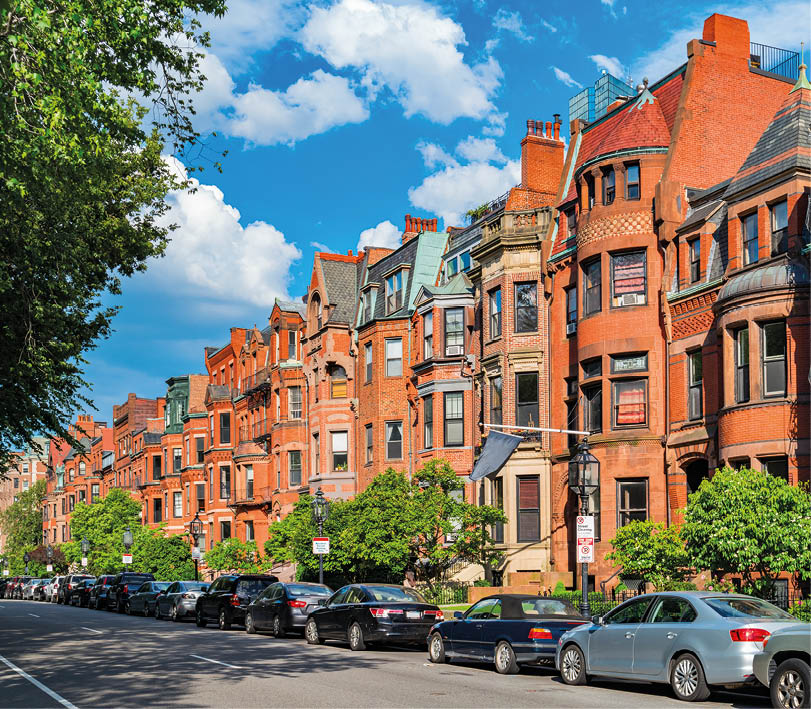 Photo of Commonwealth Avenue with typical brownstone row houses and parked cars in the Back Bay area of downtown Boston, Massachusetts, USA 