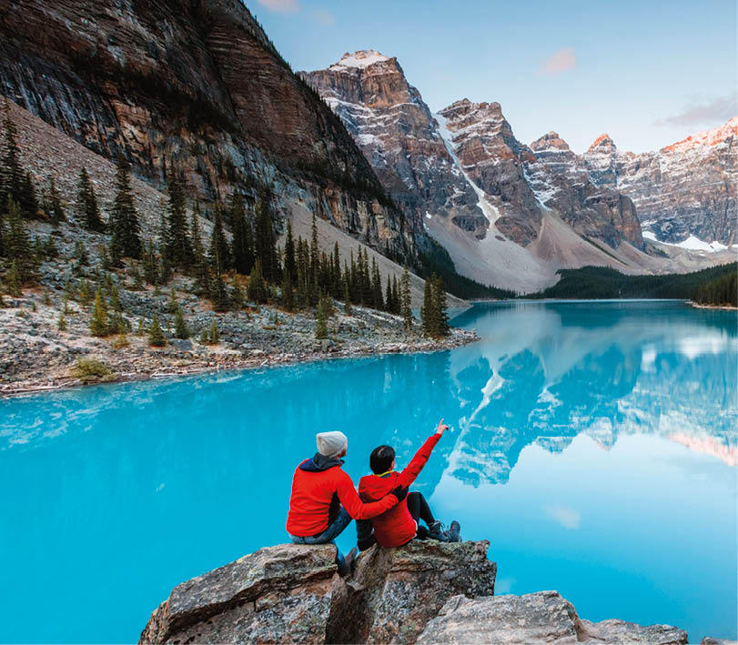 Couple looking at Moraine lake at dawn, Banff National Park, Alberta, Canada